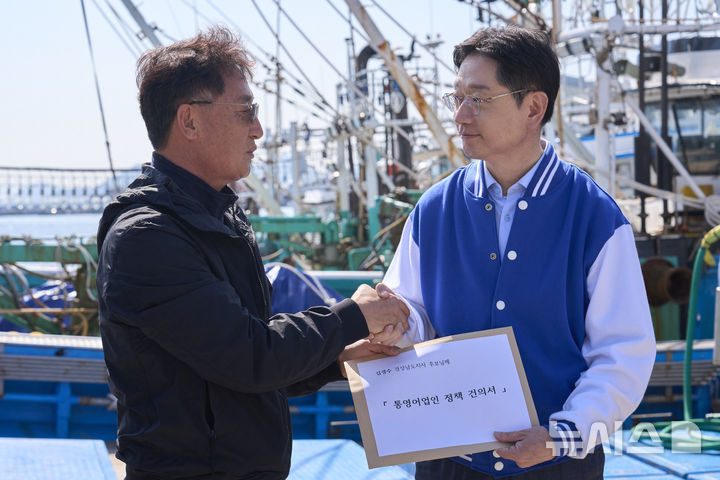 [통영=뉴시스]김경수 더불어민주당 경남도지사 후보가 2일 통영시 동호항에서 이기삼 전국어민회총연맹 사무총장으로부터 '통영어업인 정책건의서'를 전달받은 후 악수하고 있다.(사진=김경수 후보 선거사무소 제공) 2026.04.02. photo@newsis.com
