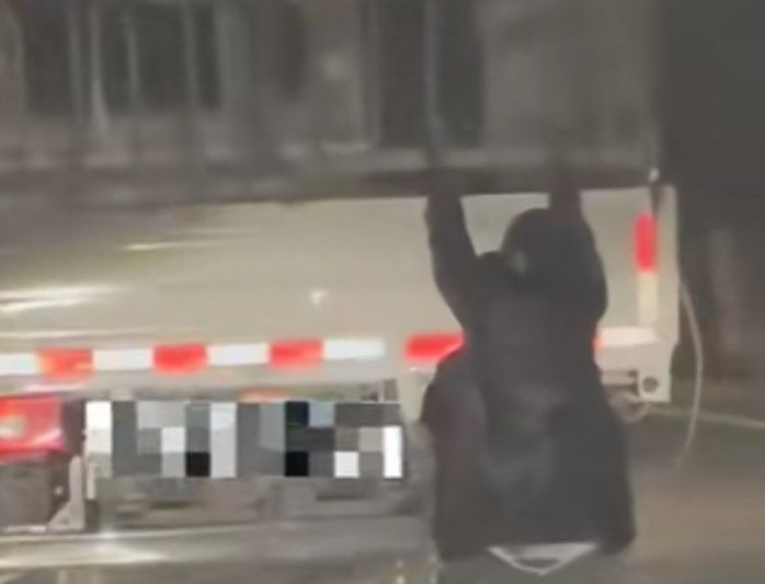 [서울=뉴시스] 2일 홍콩 사우스차이나모닝포스트(SCMP)에 따르면 지난 3월 말 저녁, 중국 신장 지역 교통경찰은 소형 트럭 뒤편에 안전장치 없이 매달린 여성을 발견하고 트럭을 정차시켰다. (사진=더우인 캡처) *재판매 및 DB 금지