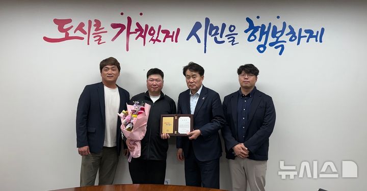 [군포=뉴시스] 하은호 시장(사진 왼쪽에서 세번째)이 환경미화원 배영제(사진 왼쪽 두번째)씨에게 모범시민 표창을 전달한 가운데 관계자들이 기념 촬영을 하고 있다.(사진=군포시 제공). 2026.04.03.photo@newsis.com