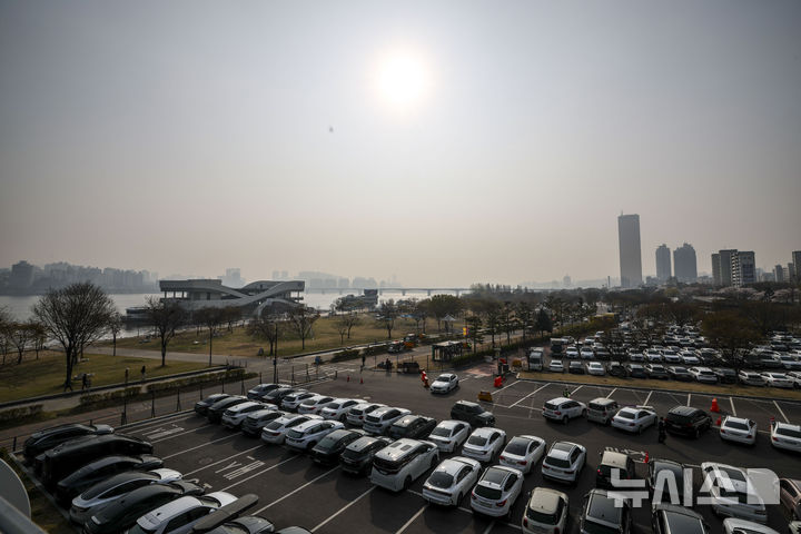 [서울=뉴시스] 정병혁 기자 = 미세먼지와 초미세먼지 농도가 나쁨 수준을 보인 3일 서울 영등포구 여의나루역 인근에서 외국인 여행객들이 벚꽃을 사진을 찍고 있다. 2026.04.03. jhope@newsis.com