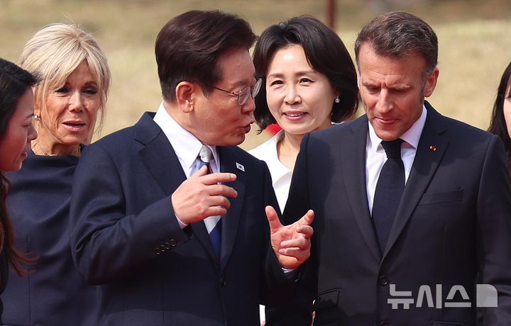 [서울=뉴시스] 고범준 기자 = 이재명 대통령이 3일 청와대에서 열린 공식환영식에서 프랑스 측 수행원 인사를 위해 이동 중 에마뉘엘 마크롱 프랑스 대통령과 대화하고 있다. 2026.04.03. bjko@newsis.com