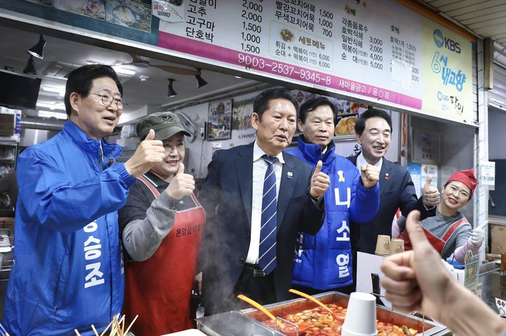 [서울=뉴시스] 조성봉 기자= 정청래 더불어민주당 대표와 양승조, 나소열, 박수현 충남도지사 경선후보가 4일 충남 아산 온양온천시장에서 상인들과 기념촬영을 하고 있다. (사진=더불어민주당 제공) 2026.04.04. photo@newsis.com *재판매 및 DB 금지