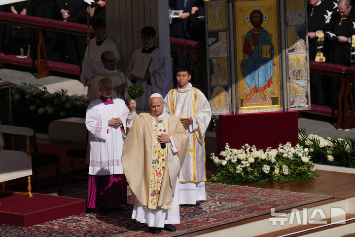 [AP/뉴시스] 레오 교황이 5일 성베드로 광장 노천 제단서 부활절 미사를 보면서 성수를 뿌리고 있다