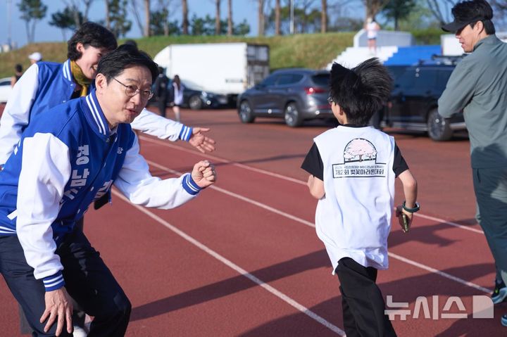 [창원=뉴시스] 더불어민주당 김경수 경남도지사 후보가 5일 오전 국립창원대학교 대운동장에서 열린 제2회 벚꽃마라톤대회 참가자들을 응원하고 있다.(사진=김경수 후보 선거사무소 제공) 2026.04.05. photo@newsis.com