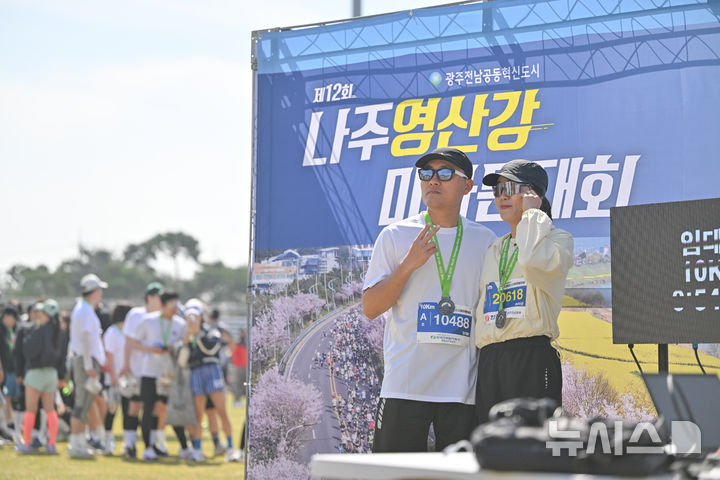 [나주=뉴시스] 이영주 기자 = 5일 오전 전남 나주종합스포츠파크에서 열린 뉴시스광주전남본부·엠디에스앤씨 주최, 나주마라톤동호회 주관 '제12회 나주영산강 마라톤대회'. 완주한 마라토너들이 포토존에서 기념사진을 촬영하고 있다. 2026.04.05. leeyj2578@newsis.com