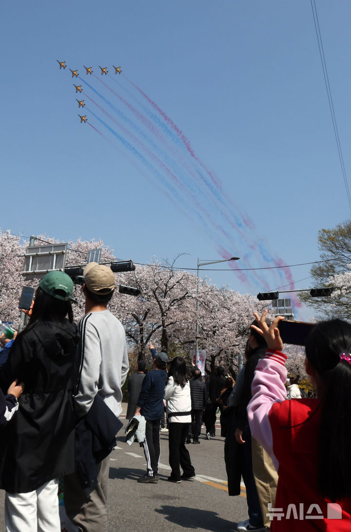[서울=뉴시스] 배훈식 기자 = 2026 영등포 여의도 봄꽃축제가 열린 5일일 오후 서울 여의도 행사장을 찾은 시민들이 공군 특수 비행팀 '블랙이글스'의 축하 비행을 보고 있다. 2026.04.05. dahora83@newsis.com