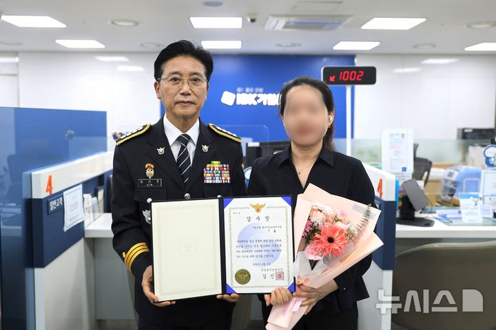 [안양=뉴시스] 김신조 안양동안경찰서장이 보이스 피싱 범죄를 예방하고 피의자 검거에 이바지한 기업은행 평촌아크로타워지점 직원 A씨에게 감사장을 전달하고 있다. (사진=안양동안경찰서 제공). 2026.04.06.photo@newsis.com