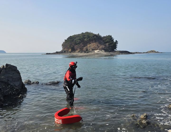 [인천=뉴시스] 지난 5일 인천 선재도 딴두부리섬에 고립된 20대 여성 2명을 구조하기 위해 인천해경 영흥파출소 경찰관이 입수하고 있다. (사진=인천해경서 제공) 2026.04.06. photo@newsis.com *재판매 및 DB 금지