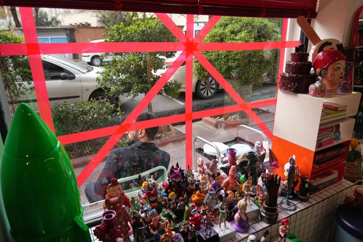 [테헤란=AP/뉴시스] 6일(현지 시간) 이란 테헤란에서 한 기념품점 주인이 폭발 충격에 대비해 가게 창문에 테이프를 붙여 놓고 그 앞에 앉아 있다. 2026.04.07.