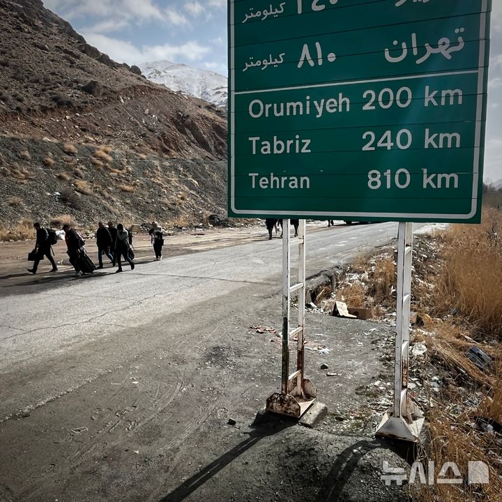 [AP/뉴시스] 지난 4일 튀르키예와의 이란 북서부 국경을 넘어온 사람들이 이란 내 여정에 오르고 있다. 남동쪽의 수도 테헤란까지 810킬로 길이다 