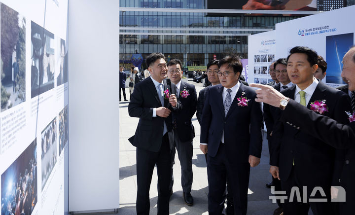[서울=뉴시스] 김선웅 기자 = 이호재 한국사진기자협회장이 7일 서울 종로구 광화문광장에서 열린 제62회 한국보도사진전 '오늘의 보도사진, 내일의 역사가 되다' 개막식에서 우원식 국회의장, 오세훈 서울시장 등 내빈들에게 전시 작품을 설명하고 있다. 2026.04.07. mangusta@newsis.com