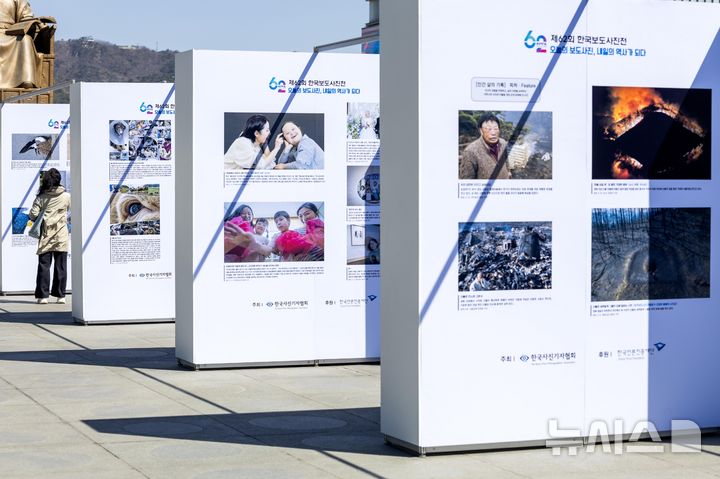 [서울=뉴시스] 사진공동취재단 = 7일 서울 종로구 광화문 광장에서 열린 제62회 한국보도사진전 '오늘의 보도사진, 내일의 역사가 되다'에서 시민들이 작품을 관람하고 있다. 2026.04.07. photo@newsis.com
