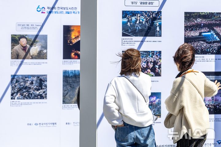 [서울=뉴시스] 사진공동취재단 = 7일 서울 종로구 광화문 광장에서 열린 제62회 한국보도사진전 '오늘의 보도사진, 내일의 역사가 되다'에서 시민들이 작품을 관람하고 있다. 2026.04.07. photo@newsis.com