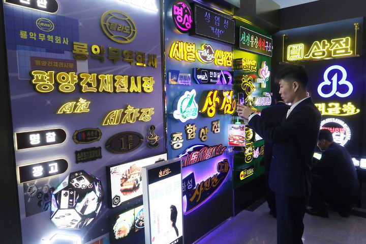 평양 산업미술 전시회 둘러보는 관람객들