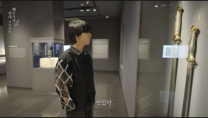 [서울=뉴시스] 슈퍼주니어 예성이 국립고궁박물관을 찾아 애니메이션 영화 '케이팝 데몬 헌터스' 속에 등장한 사인검을 보고 있다. (사진=국가유산채널 영상 갈무리) 2026.04.08. photo@newsis.com *재판매 및 DB 금지