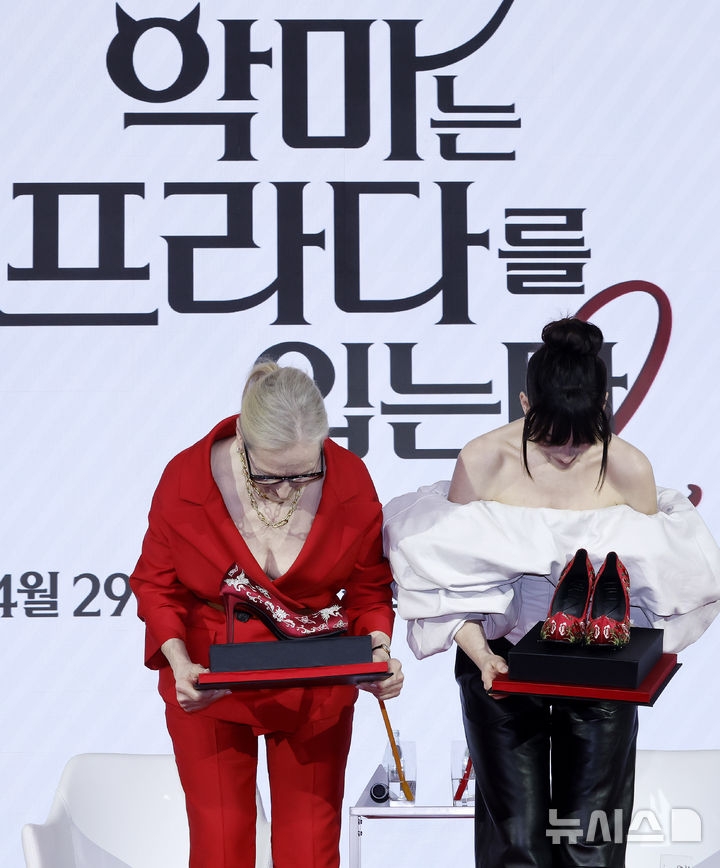 [서울=뉴시스] 김혜진 기자 = 배우 메릴 스트리프(왼쪽), 앤 해서웨이가 8일 서울 종로구 포시즌스 호텔에서 열린 영화 '악마는 프라다를 입는다2' 내한 기자간담회에서 관계자에게 꽃신 선물을 받고 고개 숙여 인사하고 있다. 2026.04.08. jini@newsis.com
