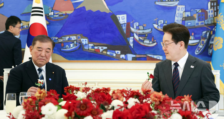 [서울=뉴시스] 최동준 기자 = 이재명 대통령과 이시바 시게루 전 일본 총리가 8일 청와대에서 오찬에 앞서 오찬장에 놓인 꽃을 들고 대화하고 있다. (청와대통신사진기자단) 2026.04.08. photocdj@newsis.com