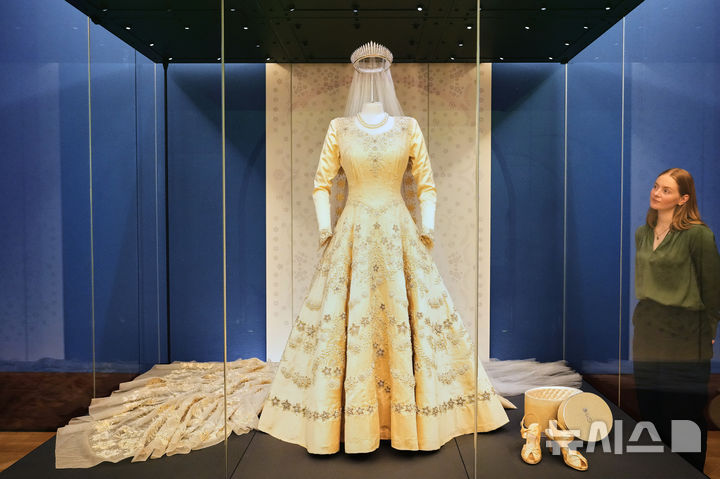 [런던=AP/뉴시스] 9일(현지 시간) 영국 런던 버킹엄 궁전 킹스 갤러리에서 열린 엘리자베스 2세 여왕의 삶과 패션을 조명하는 전시회에서 여왕이 입었던 의상이 공개되고 있다. 2026.04.11.