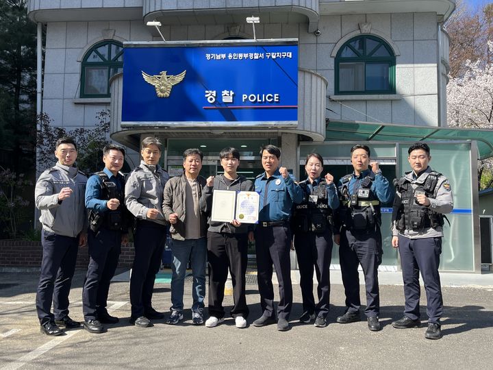 [수원=뉴시스] 용인동부경찰서 구갈지구대 앞에서 교통사고 화재현장에 뛰어들어 운전자 2명을 구조한 최대광씨(사진 가운데)가 경찰 관계자들과 감사장을 들고 기념촬영을 하고 있다. (사진=구갈지구대 제공) 2026.04.09. photo@newsis.com *재판매 및 DB 금지