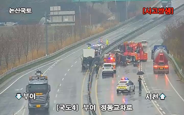 [부여=뉴시스] 9일 오전 9시49분께 충남 부여군 남면 4번 국도에서 굴삭기를 싣고 달리던 2.5t 트럭이 중앙분리대를 들이받고 멈춰선 가운데 그 위에 적재된 굴삭기가 반대편 도로로 떨어져 소방과 경찰이 도로를 통제하며 수습에 나서고 있다. (사진=경찰청 도시교통정보센터 CCTV 갈무리). 2026.04.09. photo@newsis.com *재판매 및 DB 금지