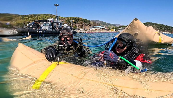 [서울=뉴시스] 8일 경남 진해만 일대에서 진행된 연합 구조전 훈련에서 한국·호주 해군 잠수사들이 모의 침몰 선박 인양을 위해 리프팅백에 공기를 주입하고 있다. (사진=해군 제공) 2026.04.09. photo@newsis.com *재판매 및 DB 금지