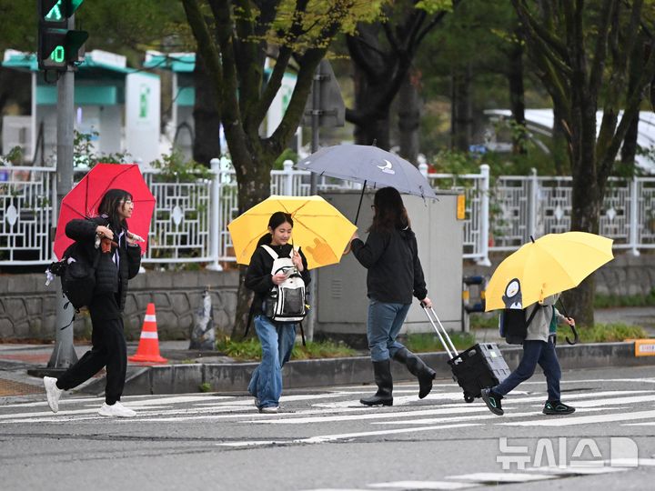 [광주=뉴시스] 이현행 기자 = 광주·전남에 최대 120㎜ 비가 예보된 9일 오전 광주 서구 치평동 한 도로에서 학생들과 시민이 우산을 쓴 채 횡단보도를 건너고 있다. 2026.04.09. lhh@newsis.com