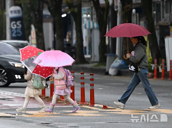 [광주=뉴시스] 이현행 기자 = 광주·전남에 최대 120㎜ 비가 예보된 9일 오전 광주 서구 치평동 한 도로에서 학생들과 시민이 우산을 쓴 채 횡단보도를 건너고 있다. 2026.04.09. lhh@newsis.com