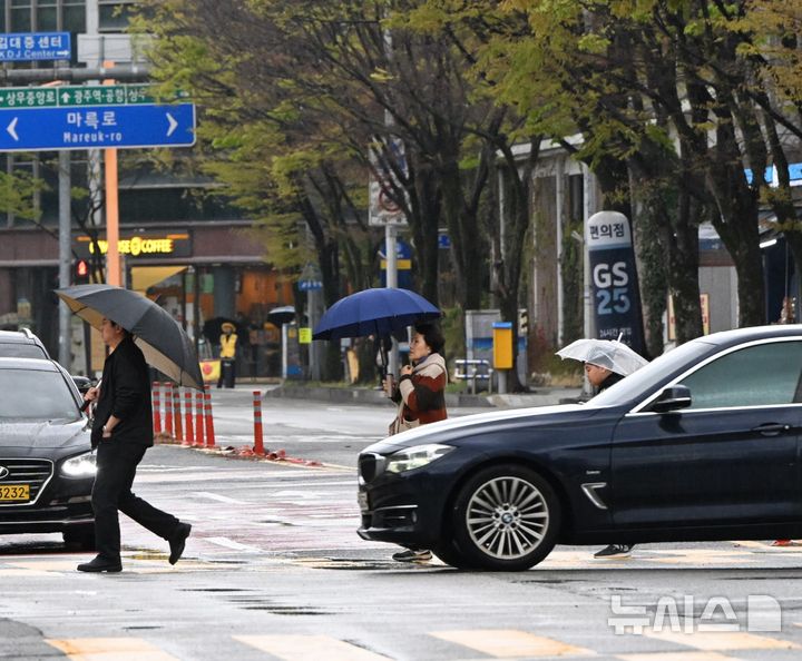 [광주=뉴시스] 이현행 기자 = 광주·전남에 최대 120㎜ 비가 예보된 9일 오전 광주 서구 치평동 도로에서 시민들이 우산을 쓴 채 횡단보도를 건너고 있다. 2026.04.09. lhh@newsis.com