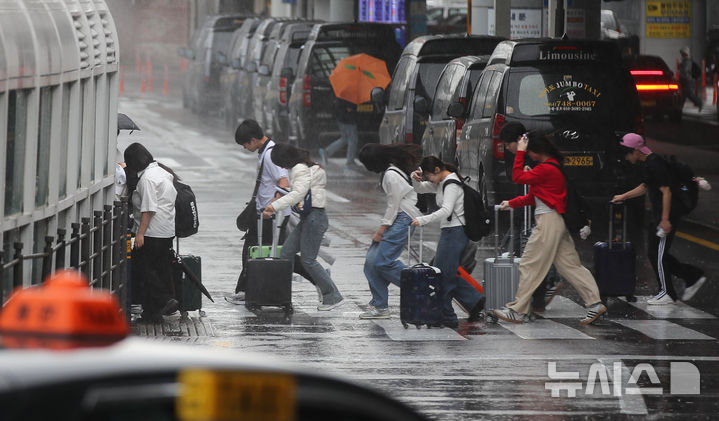 [제주=뉴시스] 우장호 기자 = 제주지역 기상이 악화한 9일 오전 제주국제공항 1층 도착장에서 이용객들이 비를 피해 달려가고 있다. 2026.04.09. woo1223@newsis.com