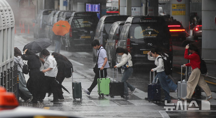 [제주=뉴시스] 우장호 기자 = 제주지역 기상이 악화한 9일 오전 제주국제공항 1층 도착장에서 이용객들이 비를 피해 달려가고 있다. 2026.04.09. woo1223@newsis.com