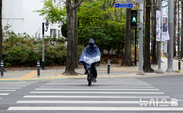 [대구=뉴시스] 이무열 기자 = 봄비가 내리는 9일 대구 중구 종각네거리 인근에서 우비를 입은 한 시민이 자전거를 타고 이동하고 있다. 2026.04.09. lmy@newsis.com