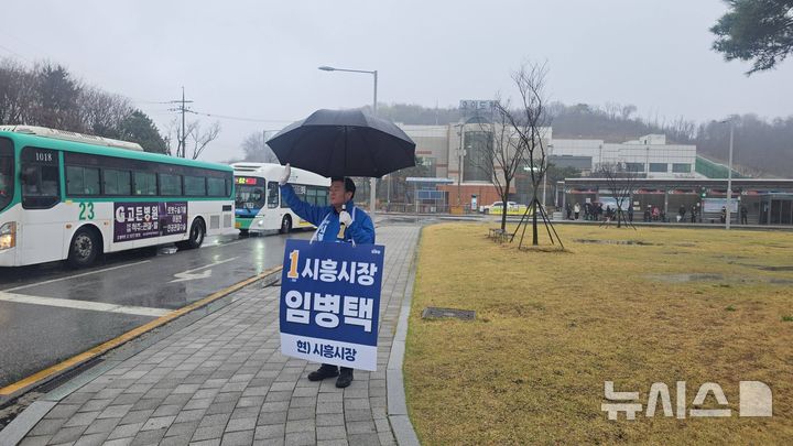 [시흥=뉴시스] 임병택 예비후보가 빗속에서도 출근길 시민들을 대상으로 아침 인사를 하는 등 선거 운동을 하고 있다. (사진=선거 사무소 제공).2026.04.10.photo@newsis.com
