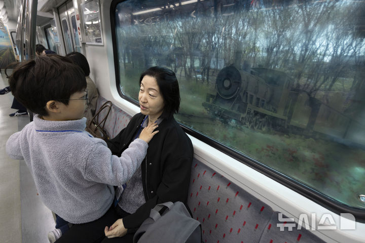 [서울=뉴시스] 청사사진기자단 = 10일 오전 서울역에서 출발해 도라산 역으로 가는 ‘DMZ 평화이음 열차’에 탑승한 김진서 군이 어머니 김물 씨와 대화를 하고 있다. 2026.04.10. photo@newsis.com