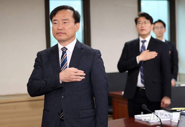 [과천=뉴시스] 최진석 기자 = 김종철(왼쪽) 방송미디어통신위원회(방미통위) 위원장이 10일 오전 경기 과천 정부과천청사에서 열린 2026년도 제1차 방미통위 회의에서 국기에 경례하고 있다. 2026.04.10. myjs@newsis.com