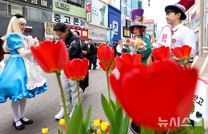 [대구=뉴시스] 이무열 기자 = 10일 대구 중구 동성로 28아트스퀘어 앞에서 이월드 원더랜드 캐릭터인 앨리스와 모자장수가 시민들에게 튤립을 나눠주는 ‘튤립 픽업 이벤트’를 진행하고 있다. 2026.04.10. lmy@newsis.com