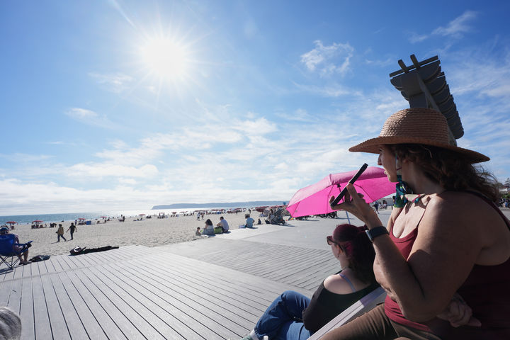 [샌디에이고=AP/뉴시스] 10일(현지 시간) 미 캘리포니아주 샌디에이고의 코로나도 해변에 모인 사람들이 아르테미스 II의 귀환을 기다리고 있다. 2026.04.11.