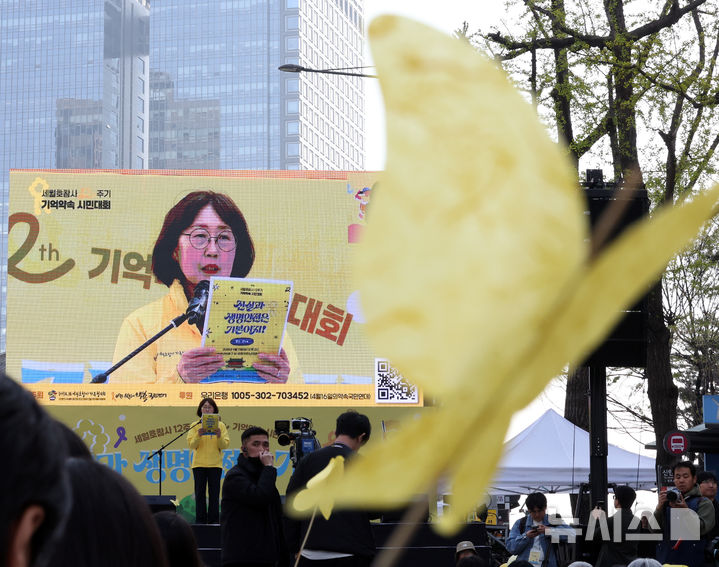 [서울=뉴시스] 최진석 기자 = 11일 서울 숭례문 인근에서 열린 세월호 참사 12주기 기억약속 시민대회에서 전광판으로 보이는 김순길 4·16세월호참사가족협의회 사무처장 앞으로 노란 종이 나비가 보이고 있다. 2026.04.11. myjs@newsis.com