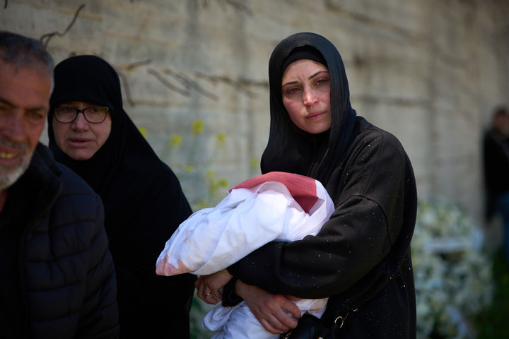 [ 시돈( 레바논)=AP/뉴시스] 이스라엘의 10일 레바논군 사령부 폭격으로 살해 당한 13명의 보안군의 한 부인이 11일의 매장식에서 남편의 무덤 앞에 서 있다.&nbsp; 사망자 가운데에는 사흘전 결혼식을 올린 20대도 포함되어 있었다. 2026.04. 12.&nbsp; 