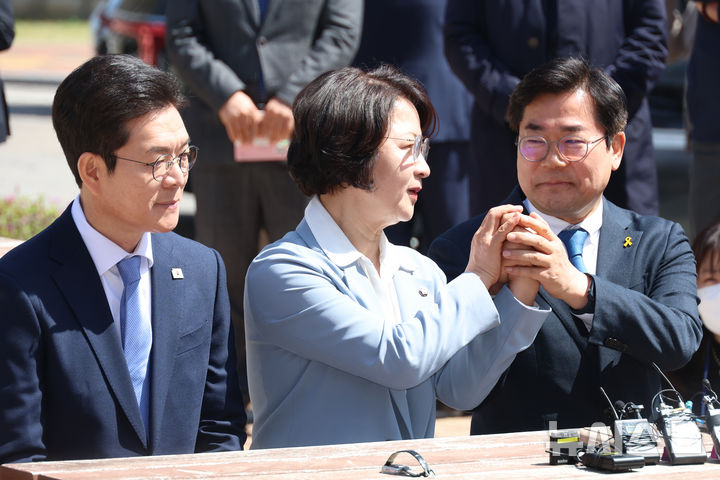 [서울=뉴시스] 고승민 기자 = 추미애 더불어민주당 경기도지사 후보가 12일 서울 여의도 국회 소통관 앞 벤치에서 열린 수도권 광역단체장 후보 '원팀 간담회'에서 인사말을 하던 중 박찬대 인천시장 후보의 손을 들어 올리고 있다. 2026.04.12. kkssmm99@newsis.com