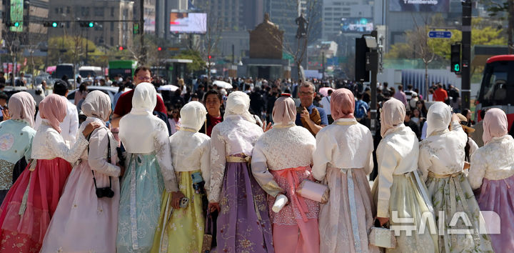 [서울=뉴시스] 추상철 기자 = 완연한 봄날씨를 보인 12일 오후 서울 종로구 광화문 앞에서 한복을 입은 외국인 관광객이 기념촬영을 하고 있다. 2026.04.12. scchoo@newsis.com