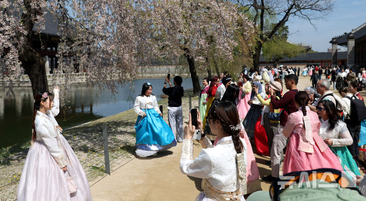 [서울=뉴시스] 추상철 기자 = 완연한 봄날씨를 보인 12일 오후 서울 종로구 경복궁에서 한복을 입은 외국인관광객이 기념촬영을 하고 있다. 2026.04.12. scchoo@newsis.com