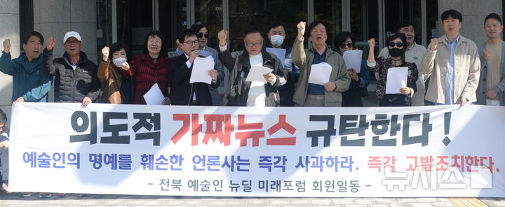 [전주=뉴시스] 김얼 기자 = 전북예술인뉴딜미래포럼 회원들이 13일 전북 전주시 전북특별자치도의회 앞에서 '의도적 가짜뉴스 규탄' 기자회견을 열고 구호를 외치고 있다. 2026.04.13. pmkeul@newsis.com