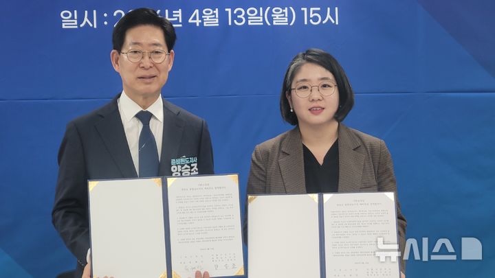 [천안=뉴시스] 최영민 기자=양승조 더불어민주당 충남도지사 경선 후보와 용혜인 기본소득당 대표가 13일 천안시청 브리핑실에서 기본소득 정책협약을 맺은 후 협약서를 펼쳐 보이고 있다 2026.04.13 ymchoi@newsis.com