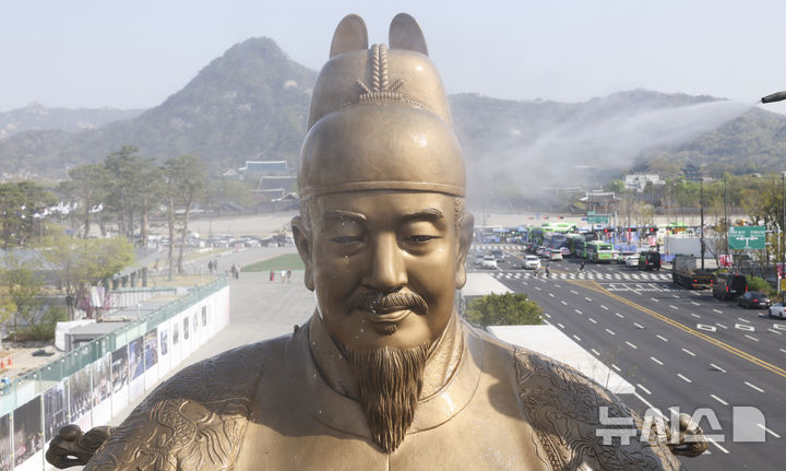 [서울=뉴시스] 권창회 기자 = 완연한 봄날씨가 찾아온 지난달 13일 오전 서울 종로구 광화문광장에서 서울시 관계자들이 세종대왕 동상을 세척하고 있다. (공동취재) 2026.04.13. photo@newsis.com