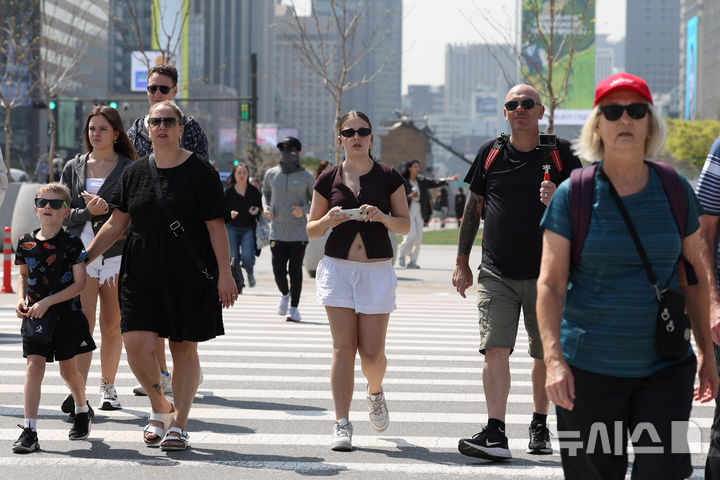 [서울=뉴시스] 조수정 기자 = 서울 낮 최고기온이 25도까지 오르며 초여름 날씨를 보인 13일 서울 종로구 광화문광장에서 한 경찰이 겉옷을 벗어 들고 걸어가고 있다. 2026.04.13. chocrystal@newsis.com