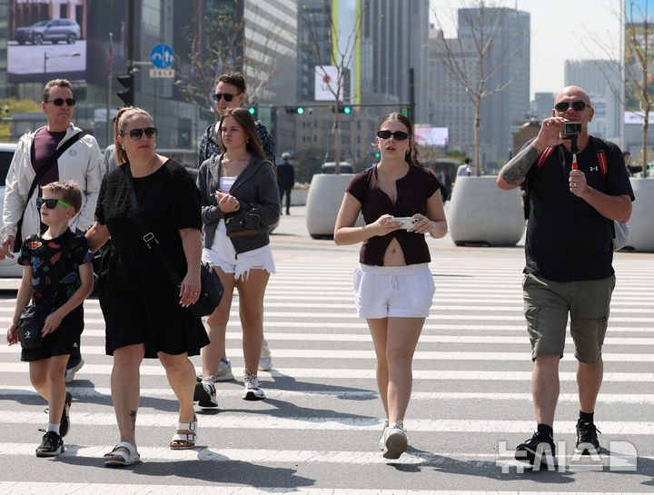 [서울=뉴시스] 조수정 기자 = 서울 낮 최고기온이 25도까지 오르며 초여름 날씨를 보인 13일 서울 종로구 광화문광장에서 외국인들이 짧은 소매와 바지 옷차림을 하고 있다. 사진은 기사 내용과 직접적인 관련 없음. 2026.04.13. chocrystal@newsis.com