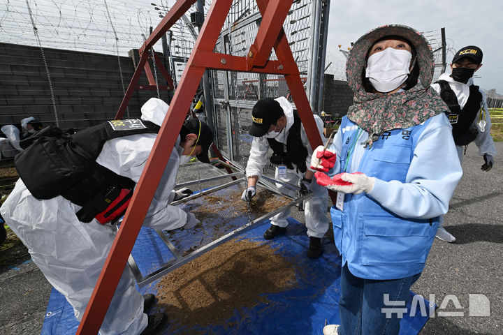 [무안=뉴시스] 이영주 기자 = 경찰 과학수사대와 12·29 무안공항 제주항공 참사 유가족협의회 관계자가 13일 오전 전남 무안국제공항 활주로에서 진행 중인 12·29 제주항공 참사 희생자 유해 재수습 작업에 참여하고 있다. 2026.04.13. leeyj2578@newsis.com