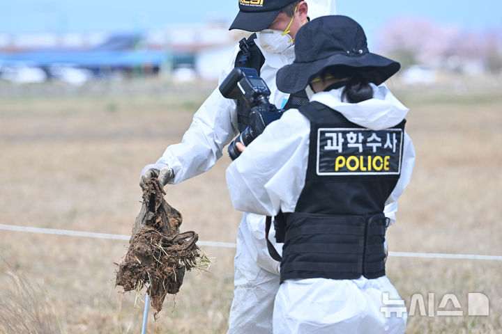 [무안=뉴시스] 이영주 기자 = 경찰 과학수사대가 13일 오전 전남 무안국제공항 활주로에서 진행 중인 12·29 제주항공 참사 희생자 유해 재수습 작업에 참여하던 중 발견한 유류품을 사진촬영하고 있다. 2026.04.13. leeyj2578@newsis.com