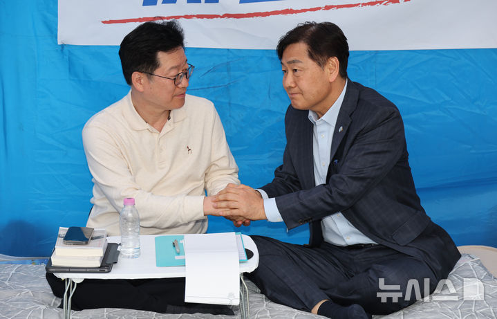 [서울=뉴시스] 김금보 기자 = 전북지사 후보로 선출된 이원택 더불어민주당 의원의 ‘술·식사비 제3자 대납 의혹’에 대한 재감찰을 요구하며 3일째 단식농성중인 안호영 의원이 13일 오후 서울 여의도 국회 본청 앞 농성장을 찾아온 김관영 전북지사와 손을 맞잡고 있다. 2026.04.13.kgb@newsis.com