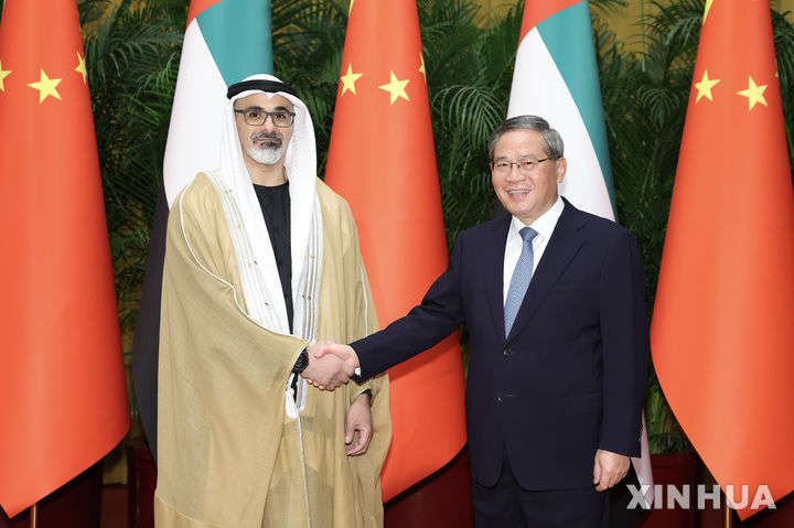 [베이징=신화/뉴시스] 리창 중국 총리(오른쪽)가 13일 중국 베이징 인민대회당에서 아랍에미리트(UAE) 아부다비 왕세자 셰이크 칼리드 빈 모하메드 알 나흐얀과 회담에 앞서 악수하고 있다. 2026.04.14 